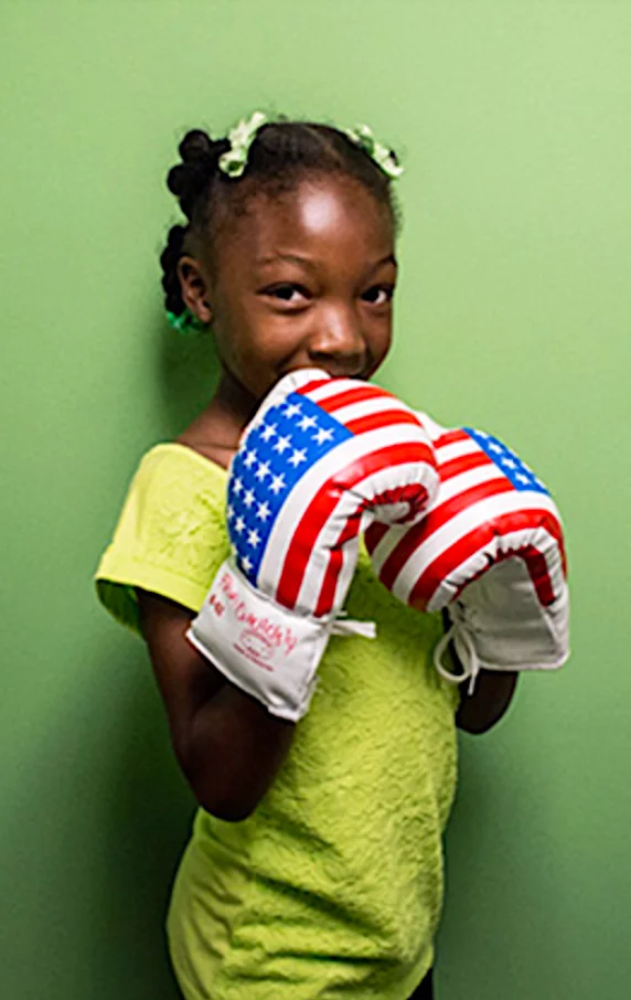 Black girl wearing boxing gloves
